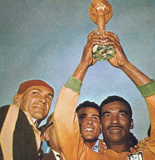 Didi levanta a Taça Jules Rimet, em 1958, na Suécia. À esquerda, Paulo Amaral. Entre ele e o homem atrás de Didi está Paulo Machado de Carvalho.

