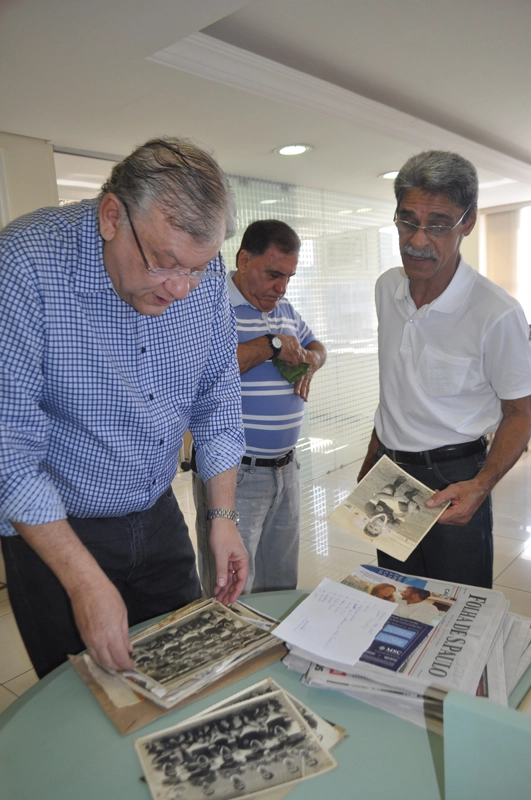 Milton Neves observa fotos trazidas por Zezinho (à direita)  na redação do Portal Terceiro Tempo em 20 de agosto de 2014. Atrás, Bentivegna. Foto: Marcos Júnior/Portal TT