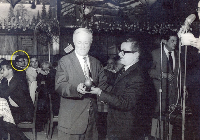 Emílio Colella entrega um troféu a Thomaz Mazzoni, ao fundo vemos Roberto Petri (com círculo amarelo), enquanto à direita aparece Otávio Munis. Foto: Arquivo ACEESP