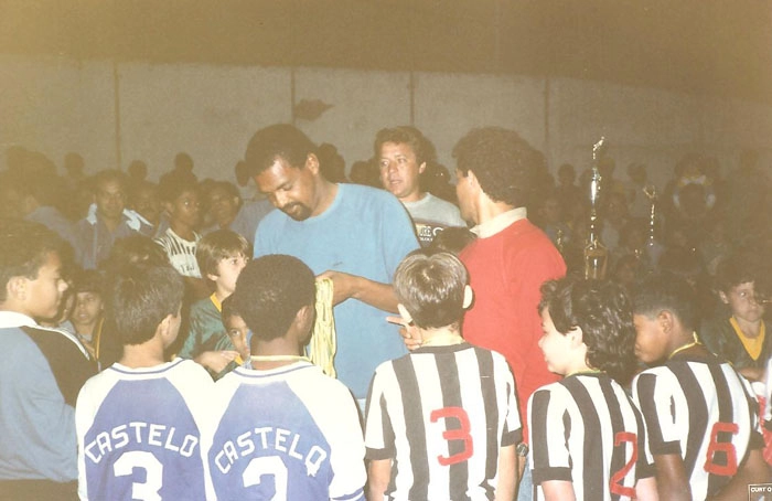 Na Escola de Futebol Bosque Sports, em 1987, garotos recebem medalhas das m&atilde;os de Luis Pereira. Na sequ&ecirc;ncia, depois do 