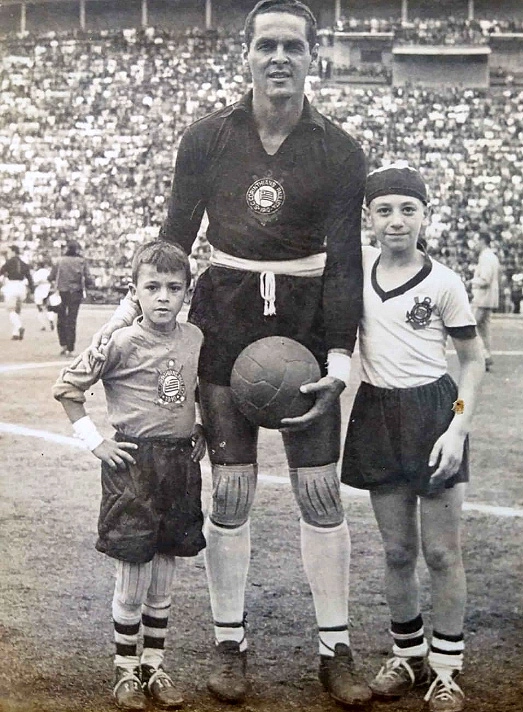 Em 1960, Gylmar no Pacaembu lotado, posando com dois mascotes corintianos. Quem serão os menininhos ladeando o goleiro alvinegro? Foto: arquivo do Portal Terceiro Tempo