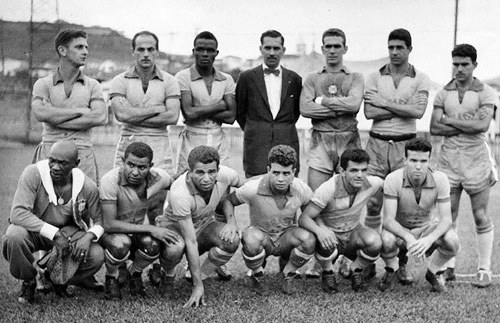 Equipe em um coletivo, iniciando os preparativos para a Copa de 1958: De Sordi, Dino Sani, Zózimo, Castilho, Mauro Ramos de Oliveira e Cacá; Agachados: massagista Mário Américo, Canhoteiro, Vavá, Almir, Dida e Zagallo.  Crédito foto: Arquivo Nacional

