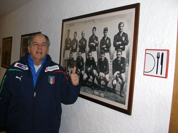 Marcos Falopa e o quadro que está na sede do Milan. Formação do Milan. Dino Sani é o terceiro em pé, da esquerda para a direita. O primeiro agachado é Trapattoni, e o quarto é Mazzola. O quadro está na sala da casa do treinador Marcos Falopa