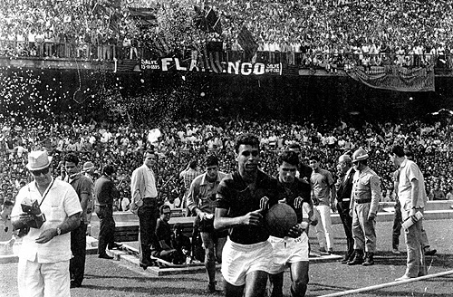 Duzentas mil pessoal abarrotaram o Maracanã na final do campeonato carioca de 1963. Carlinhos (com a bola na mão) e Paulo Henrique entram em campo para enfrentar o Fluminense. O Marcial vem logo atrás deles.

