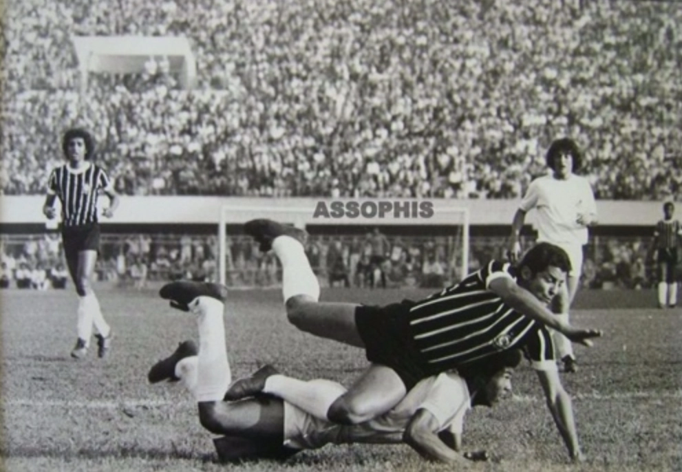 Vaguinho caindo sobre Bianchi durante um Corinthians x Santos no Pacaembu, por sinal, lotado. Atrás deles, Basilio, Léo Oliveira e mais ao fundo, à direita. Wladimir. O goleiro corintiano, no gol do tobogã, é Paulo Rogério. Foto: ASSOPHIS (Associação dos Pesquisadores e HIstoriadores do Santos F.C)