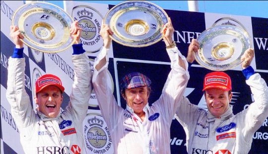 Johnny Herbert, à esquerda, venceu a única prova para a equipe de Jackie, a Stewart Grand Prix. Stewart, comemora ao lado de Barrichello, terceiro colocado, no pódio do Grande Prêmio da Europa de 1999, em Nurburgring. Foto: Divulgação