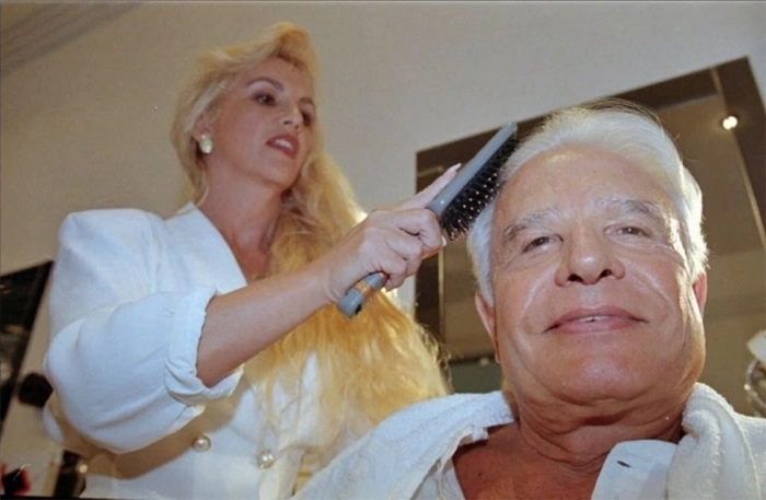 O apresentador Cid Moreira é penteado por Ulhiana, sua esposa na época, em seu camarim, no dia 30 de março de 1996. Foto: FSP-Ilustrada (Bol)