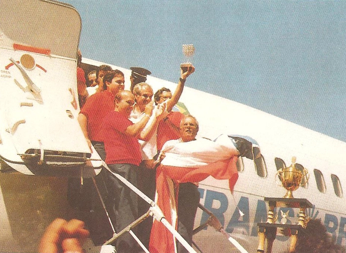 Desembarque da delegação do Bahia em Salvador, após conquistar o título da Copa União de 1988. Evaristo ergue a taça. À esquerda, no degrau mais abaixo, de camisa vermelha, o presidente do Bahia na ocasião, Paulo Maracajá. Reprodução: Revista Exclusiva, edição de março de 1989