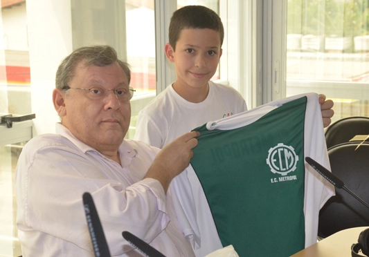 Em 2012, Milton Neves viajou até Criciúma e reencontrou grandes amigos do futebol. Nesta imagem, Milton mostra a camisa do Esporte Clube Metropol, time de grande sucesso na década de 60, que teve muitos craques em sua história