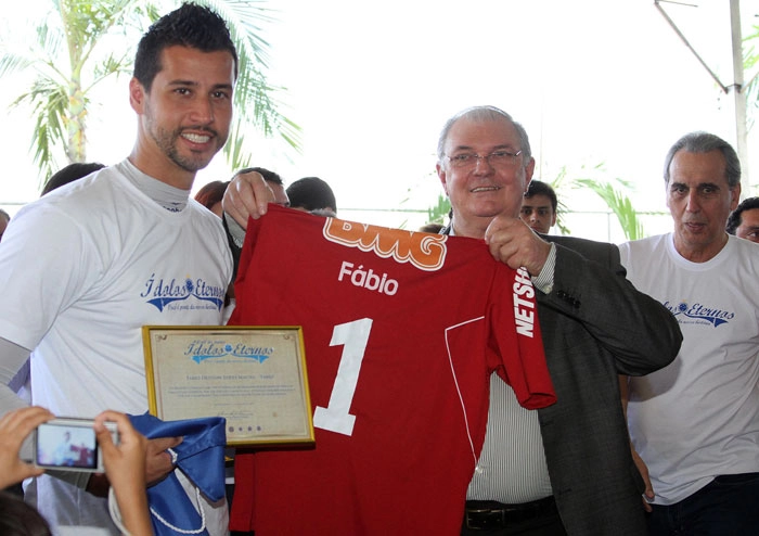 Enquanto Gilvan Tavares, presidente do Cruzeiro, ergue a camisa do goleiro Fábio, o ex-lateral Nelinho observa tudo, no canto direito da foto. Foto: VIPCOMM