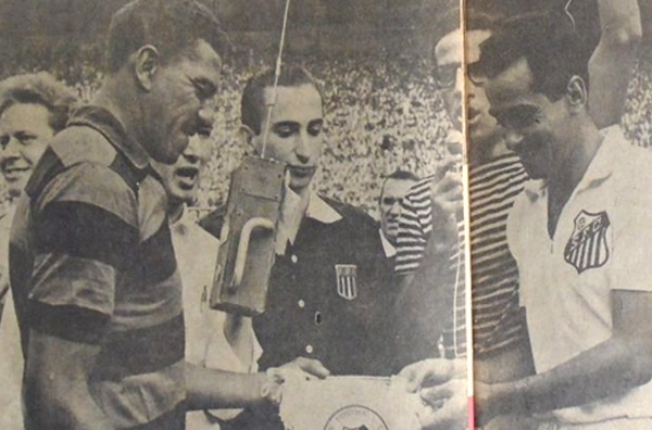 Sob o olhar do árbitro Romualdo Arppi Filho, Jadir recebe uma flâmula do capitão Zito. Foto: revista do Esporte, número 177 – Julho de 1962, enviada por Moises Bueno