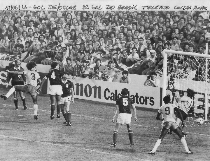 Com a camisa 3 da Seleção Brasileira, Oscar marca de cabeça sobre a Escócia, na primeira fase da Copa do Mundo de 1982. O camisa 9, de costas, é Serginho Chulapa