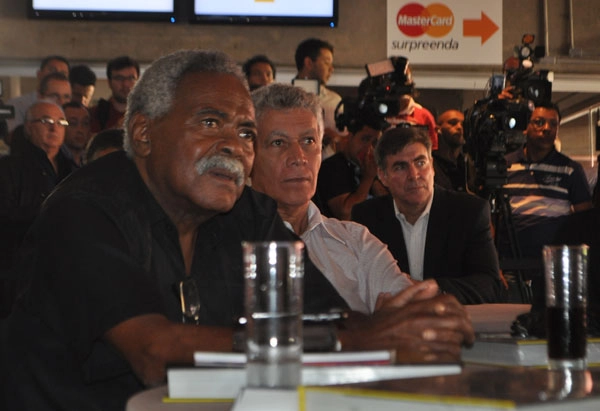 Atento, Coutinho ouve o discurso de Aldo Rebelo, ministro do Esporte, ao lado de Clodoaldo. À direita de Clodoaldo, um pouco mais atrás, está Zetti. Ao fundo, à esquerda (de óculos) está o repórter Luís Carlos Quartarollo. O último, à direita, é o cinegrafista Cristian Bartalo. Eles compareceram ao almoço dos campeões mundiais de futebol em 25 de abril de 2013, no Espaço Unyco, no Estádio do Morumbi. Foto: Marcos Júnior/Portal TT