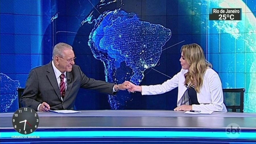 Joseval Peixoto em sua despedida do SBT, em 28 de dezembro de 2018, sendo cumprimentado pela colega de bancada no SBT Brasil, Rachel Sherehazade. Reprodução