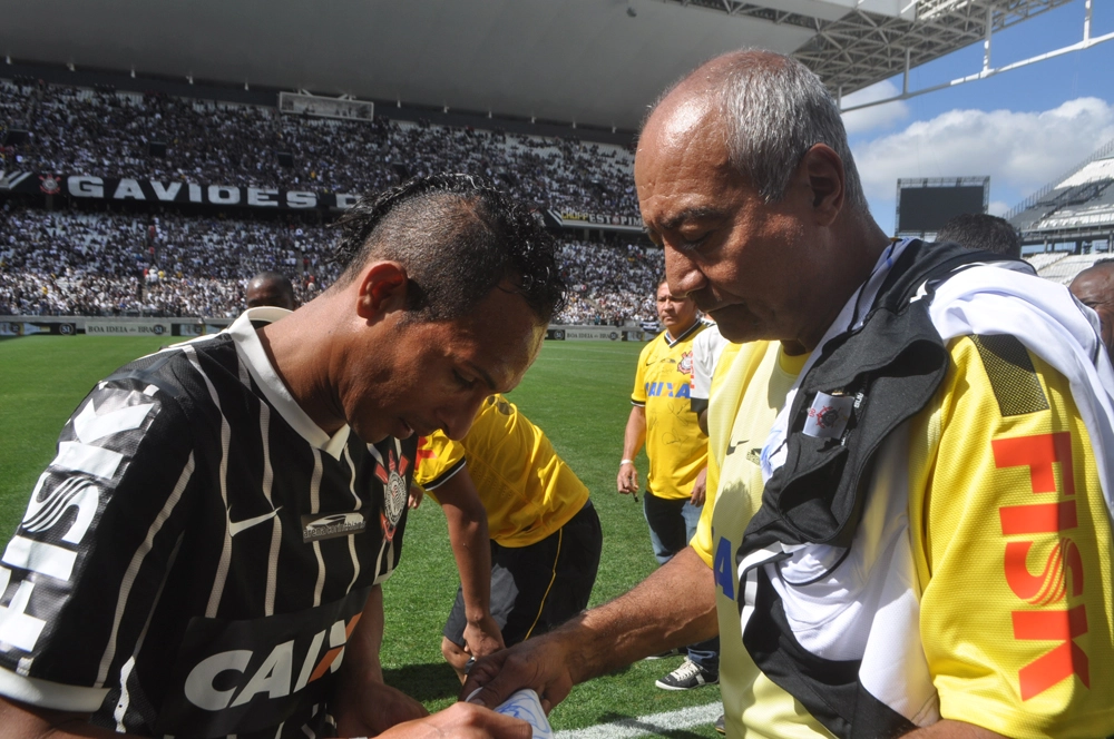Liédson autografa camisa para Tobias em 10 de maio de 2014 na Arena Corinthians. Foto: Marcos Júnior/Portal TT