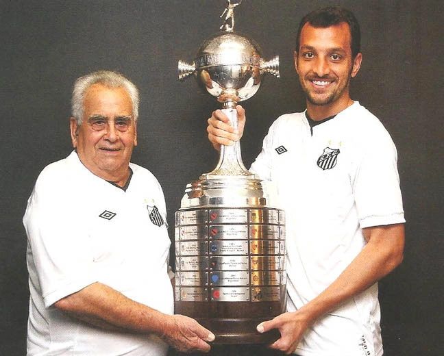 Zito e Edu Dracena, felizes, com erguendo o troféu da Libertadores da América, três vezes levantada pelo Santos. Reprodução: Revista Santástico, edição nº6 (julho/agosto de 2011)