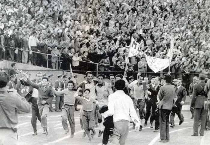 À frente, Garrincha aparece abraçado com um torcedor, enquanto o volante Zito está mais atrás, concedendo entrevista ao jornalista Milton Peruzzi. Foto: Reprodução/Revista Nossas Copas
