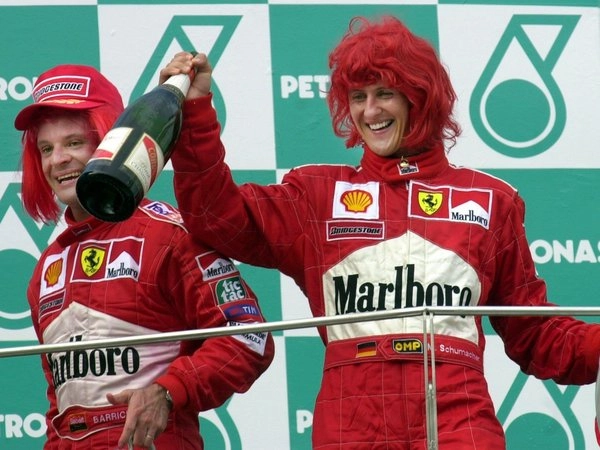 Rubens Barrichello e Michael Schumacher em 2000, comemorando no pódio com perucas vermelhas. Foto: Divulgação
