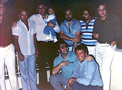 Jos&eacute; Silv&eacute;rio, o ent&atilde;o chefe de esportes da Jovem Pan, morava na Rua Timburi (hoje Rua Il Sogno Di Anarello), no bairro do Ibirapuera, em S&atilde;o Paulo, reuniu o time da r&aacute;dio para comemorar o anivers&aacute;rio de uma de suas filhas. &Agrave; &eacute;poca, G&eacute;rson, o Canhotinha de Ouro, era nosso comentarista. Na foto, n&atilde;o muito n&iacute;tida, est&atilde;o, da esquerda para a direita: Edemar Annuseck, G&eacute;rson, eu (segurando meu filho Rafael), o querido C&acirc;ndido Garcia, Sergio Barbalho, Fl&aacute;vio Adauto e, agachados, o ent&atilde;o gordinho Jos&eacute; Silv&eacute;rio e o genial Odayr Batista.
