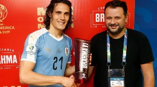 Cavani (e) recebe o prêmio de melhor em campo das mãos de Toninho, dono do Bar do Momo (RJ), após jogo no Maracanã 